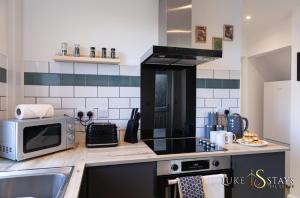 a kitchen with a microwave oven and a sink at Luke Stays - Finchale Ave in Sheepscar