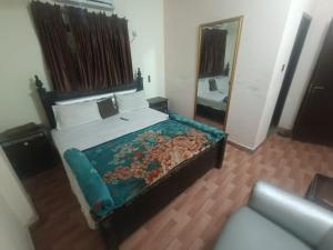 a bedroom with a large bed and a mirror at Hotel Lahore City in Lahore