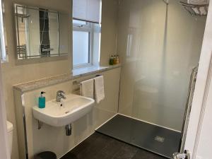 uma casa de banho com um lavatório e um chuveiro em Cornerways Llandudno em Llandudno