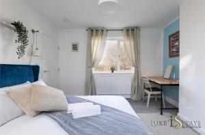 a bedroom with a white bed and a desk and a window at Luke Stays - Finchale Ave in Sheepscar