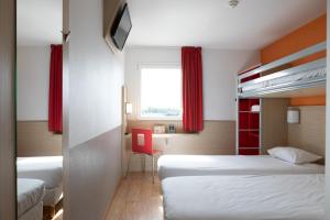 アンドレジュー・ブテオンにあるThe Originals Access,Tendance Hôtel, Saint-Etienneのベッドルーム1室(ベッド2台、赤い椅子付)