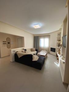 - une grande chambre avec un grand lit et une télévision dans l'établissement Olea House 2' walk from the sea, à Nótos