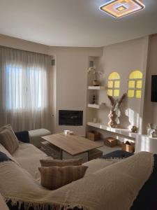 a living room with a couch and a table at Olea House 2' walk from the sea in Nótos