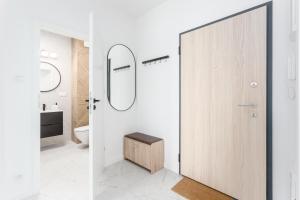 a bathroom with a toilet and a wooden door at Warsaw City Jutrzenki Premium in Warsaw +94 photos