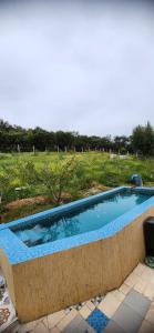einen Pool in einem Garten mit einem Feld in der Unterkunft Gite Aguelmous réservé aux familles 
