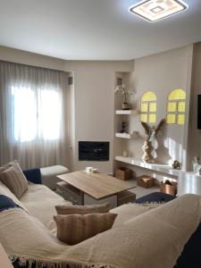 a living room with a couch and a table at Olea House 2' walk from the sea in Nótos