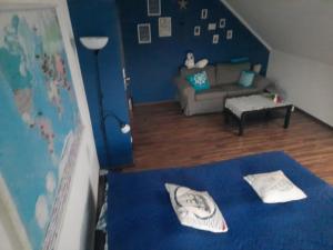 Zimmer mit einem blauen Bett und einem Wohnzimmer in der Unterkunft NOCLEGI u ANI in Otmuchów