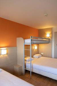 アンドレジュー・ブテオンにあるThe Originals Access,Tendance Hôtel, Saint-Etienneのオレンジ色の壁の客室で、二段ベッド2台が備わります。