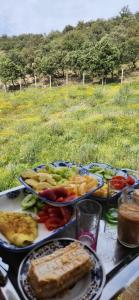 einen Tisch mit Teller mit Lebensmitteln auf einem Feld in der Unterkunft Gite Aguelmous réservé aux familles 