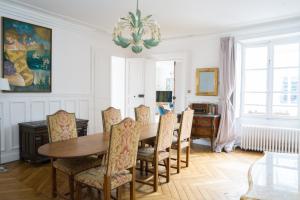 uma sala de jantar com mesa e cadeiras em Magnifique appartement au coeur de Versailles em Versailles