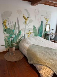 een slaapkamer met een bed met een vogelmuurschildering aan de muur bij L' Appart cocoon in Joinville