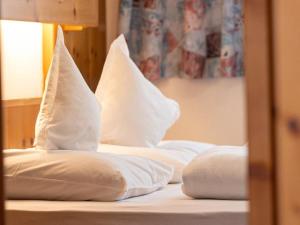 - 2 oreillers blancs installés au-dessus du lit dans l'établissement Rastenfeldhof, à Parcines