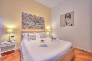 a bedroom with a large white bed with two lamps at Aparthotel Arona in Arona