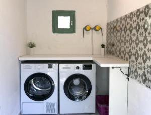 eine Waschküche mit einer Waschmaschine und einer Theke in der Unterkunft Green House!! in Sfakerá