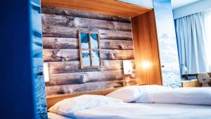 una camera con 2 letti e una parete in legno di Boutique Hotel Kronenhof a Zurigo