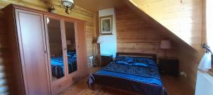 1 dormitorio con 1 cama en una cabaña de madera en Sowi Dwór, en Nałęczów