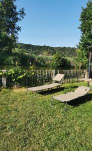 dwa stoły piknikowe w trawie blisko ogrodzenia w obiekcie s´Paradies Ferienwohnung w mieście Beilngries