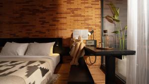 a woman sitting on a table next to a bed at Titik Dua Ubud in Ubud
