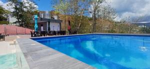 a swimming pool with blue water in front of a house at Sky Seaview Coron in Coron