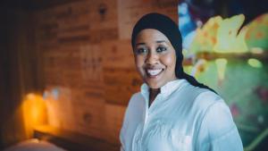 a woman wearing a hijab smiles at the camera at Boutique Hotel Kronenhof in Zurich