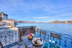 a table with a bowl of fruit on a balcony overlooking the water at Aparthotel Arona - Happy Rentals in Arona