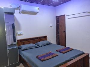 Rúm í herbergi á Maison Parnakuti Adigas Homestay Dharmasthala Guest House Hotel Room