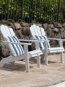 two white chairs with blue and white striped pillows at Mollymook Seascape Motel and Apartments in Mollymook