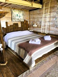a bed in a wooden room with towels on it at Tuz Treehouse in Politika