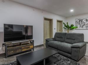 een woonkamer met een bank en een flatscreen-tv bij Holiday Home Josipović 
