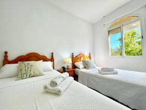 a bedroom with two beds with white sheets and a window at GATU LUCIA 3dormit 2 baños terraza aire acc in El Puerto de Santa María