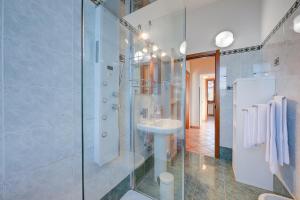 bagno bianco con lavandino e doccia di Aparthotel Arona ad Arona Altre 37 foto