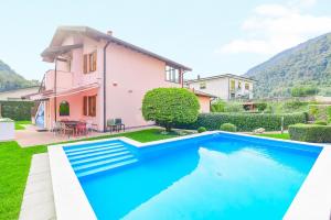 a villa with a swimming pool in front of a house at Jane e Jolie holiday home private swimming pool in Valbrona