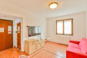 a living room with a red couch and a flat screen tv at Jane e Jolie holiday home private swimming pool in Valbrona