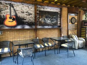 une chambre avec des tables et des chaises et une guitare sur le mur dans l'établissement Apartments DS Club, à Budva