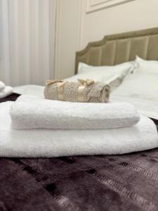 a pile of towels sitting on top of a bed at Luxury RA Apartment in Oradea