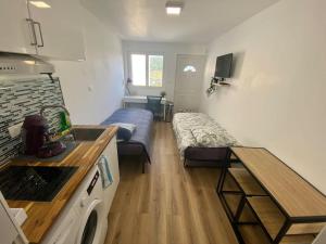 Kleines Zimmer mit einer Küche und einem Bett. in der Unterkunft Cosy Studio neuf centre-ville in Orsay