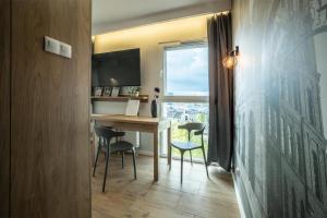 a room with a desk and chairs and a window at WiguryTower Apartaments 98 in Łódź