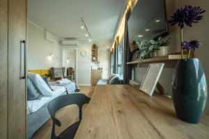 a living room with a couch and a vase on the floor at WiguryTower Apartaments 98 in Łódź