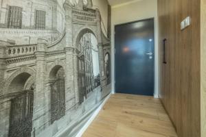 a hallway with a door with a drawing on the wall at WiguryTower Apartaments 98 in Łódź +12 photos
