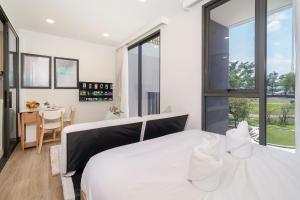 Un dormitorio con una gran cama blanca y una mesa en Laguna BangTao Beach skypark Apartment en Phuket