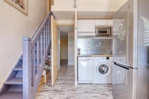 a laundry room with a washer and dryer in a house at Duplex T3, terrasse 18m2 vue mer, proche plage in Le Lavandou