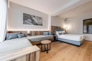 a hotel room with two beds and a table at Hotel Eccher 3 stelle Superior in Mezzana