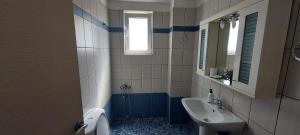 ein Badezimmer mit Waschbecken, Toilette und Spiegel in der Unterkunft Momenti Felici 2 in Artemida + 16 Fotos