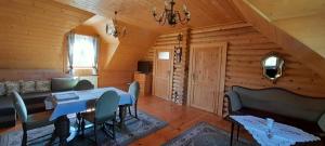 - un salon avec une table et des chaises dans une cabine dans l'établissement Sowi Dwór, à Nałęczów