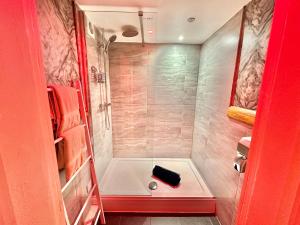 a small bathroom with a shower with a tub at Beyond - Romantic Basement Apartment - Close To Beach - With Parking in Bournemouth