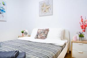 sypialnia z białymi ścianami i łóżkiem z niebieskim kocem w obiekcie Grandera Apart`s - Sollana 18 w Walencji