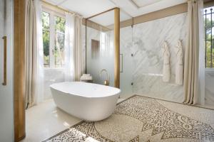 a bathroom with a large white tub and a shower at Grand-Hôtel du Cap-Ferrat, A Four Seasons Hotel in Saint-Jean-Cap-Ferrat