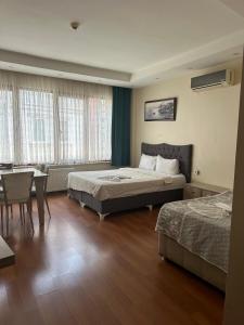 伊斯坦堡的住宿－比林奇公寓酒店，酒店客房带两张床和一张桌子以及椅子。