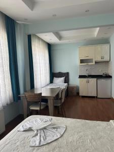 a room with two beds and a table and a kitchen at Birinci Apart Hotel in Istanbul