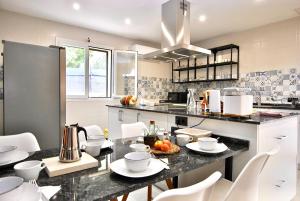 a kitchen with a table with white chairs in it at Villa Placid, casa con piscina dentro del pueblo in Pina